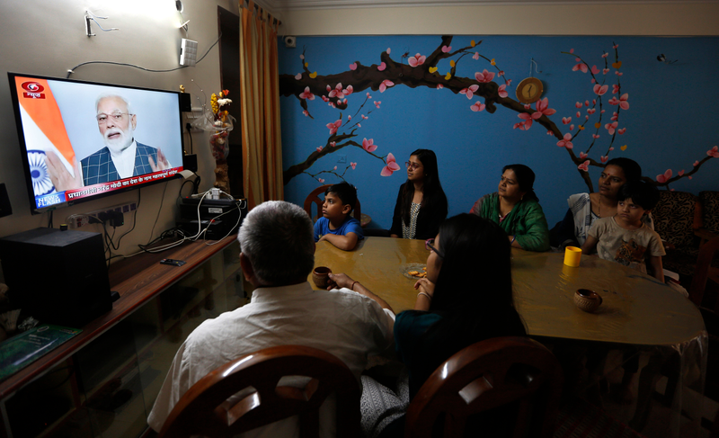 A family in India watches prime minister Narendra Modi addressing the nation during a televised address on March 27, 2019.